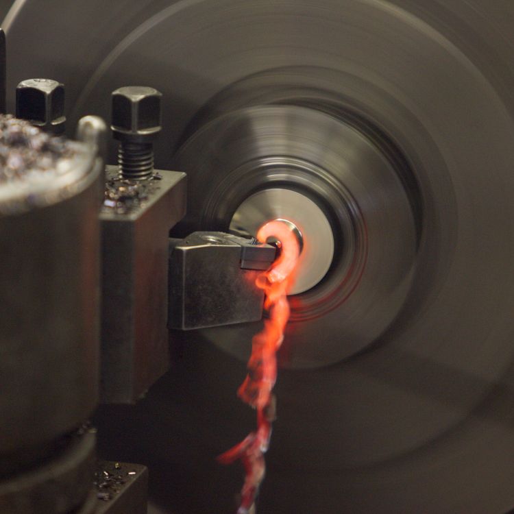 Zu sehen ist die Metallbearbeitung an einer Drehmaschine mit rotglühendem Span bei einer Rekalibrierungsprobe.